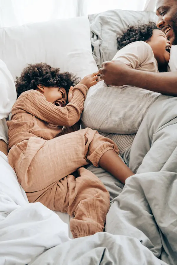 Mother and child laughing in bed